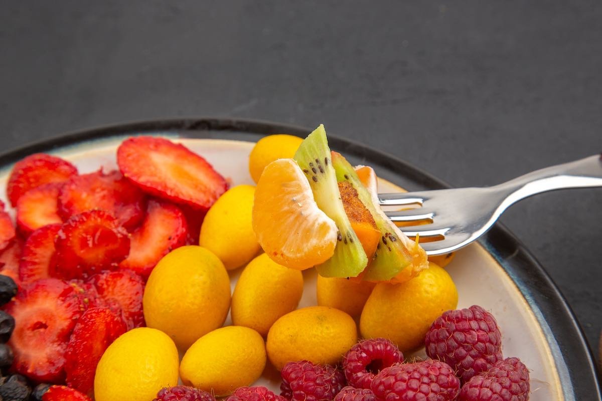 front view tasty sliced fruits with fresh berries and fruits on a dark background mellow exotic tropical fruit healthy life